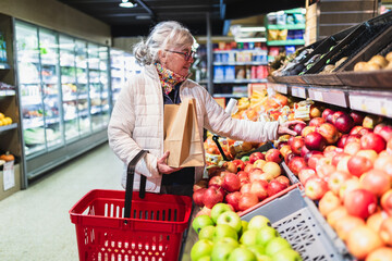 Senior Woman Selecting Fresh Apples in Grocery Store
