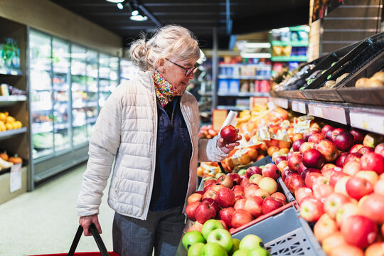 Senior Woman Selecting Fresh Apples in Grocery Store
