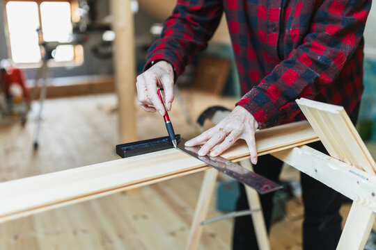 Senior Woman Measuring Wood for DIY Home Renovation Project