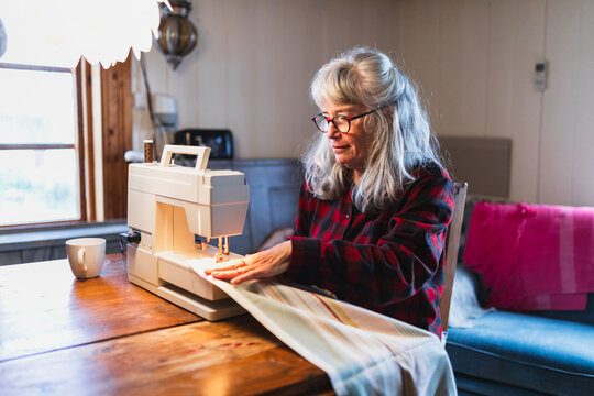 Senior Woman Sewing with Machine in Cozy Home