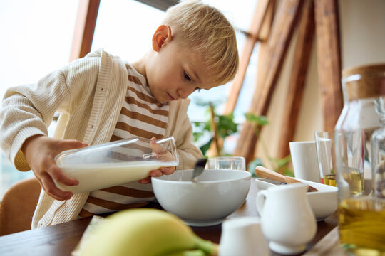 Little boy prepares cereals for breakfast