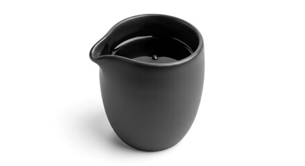 Minimalist aesthetic of a black ceramic creamer filled with dark liquid on white background
