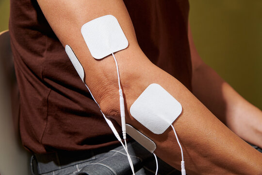 a man showing electrodes from an electrostimulation device