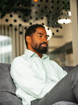 Relaxed Man Sitting on Sofa in Modern Office Lounge in the Meeting