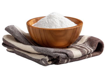 Wooden bowl filled with white powder on striped cloth against black background image