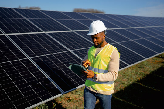 Solar panel technician conducts maintenance check on solar farm