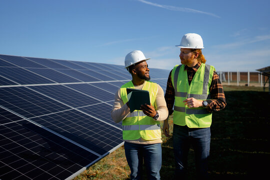 Two solar panel technicians inspect a renewable energy site