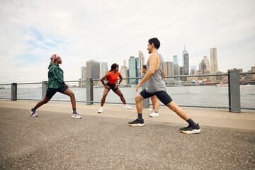 Friends engaging in a workout session by the riverbank