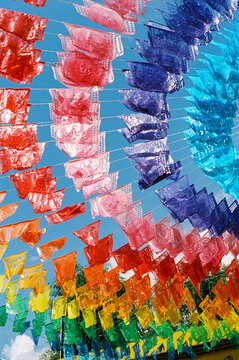 Film photo of brightly colored papel picado decoration overhead
