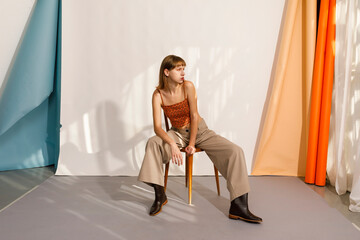 Model Poses on a Chair in a Stylish Studio Setting