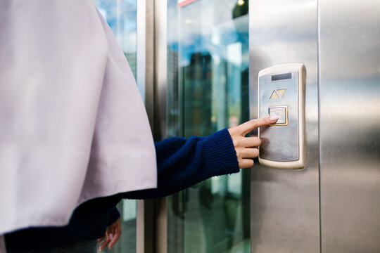 Woman pressing elevator down button for access