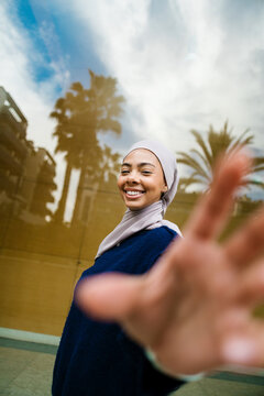 Young woman in hijab smiling taking selfie