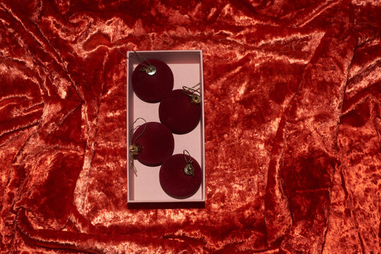 Ornaments in a box on velvet red fabric