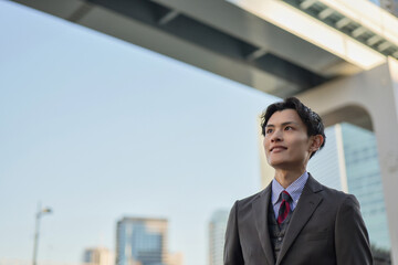 肯定的な表情で未来を見つめるビジネスマン