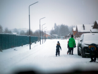 family crossing street in front of the vehicle