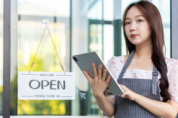 Female owner of coffee shop or restaurant turning round sign to open. Smiling young asian woman owner, employee retail coffee shop woman hand in setting sign board to open for welcome customer, reopen