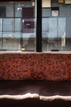 Empty Train Seat with Passengers reflected on Window 