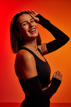 Woman smiling with sunlit background during indoor photo session