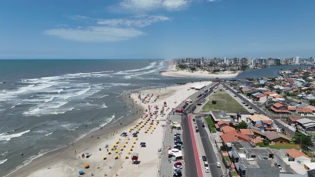 Cinematic drone aerial wide shot of Tramanda&iacute; River mouth meeting the Atlantic Ocean with beach and city skyline in Rio Grande do Sul Brazil. High quality 4K 60fps video.