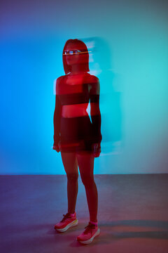 Woman poses with dynamic light effects in modern studio space