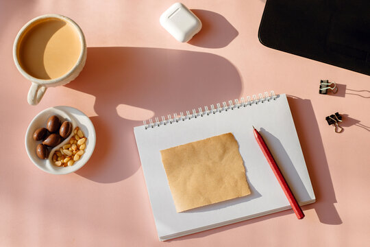Above view of office desk with notes, laptop and coffee cup.