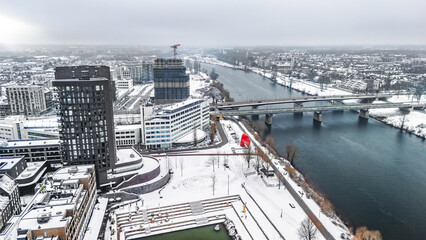 Snowy Venlo town waterfront near Maas river aerial drone view, winter cityscape with rooftops covered with snow, winter weather in Limburg, the Netherlands