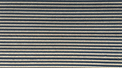 Aerial drone view of plowed agricultural field ready for planting, rows of soil agriculture background