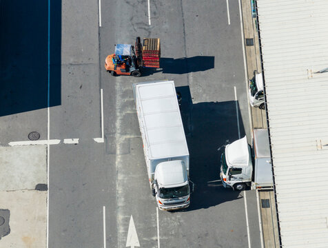 Forklift Loading Cargo onto Delivery Truck from Above