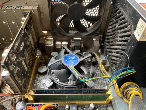 Purwokerto, Indonesia - 17 March 2026: Dusty computer interior showing Intel CPU cooler fan, motherboard, and cables inside an old PC case.