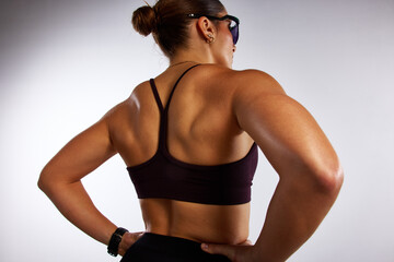 Strong athlete showing toned back muscles in fitness studio