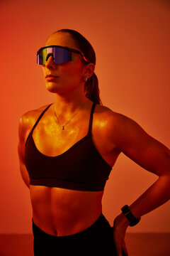 A confident athlete stands still, showcasing a strong physique