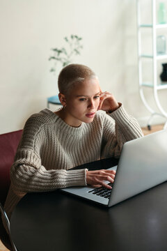 Focused Woman Works Intently at Laptop in Cozy Indoor Space