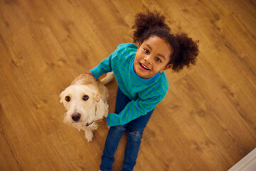 Little girl hugs her dog with joy