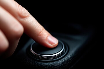Human finger pressing a control button with a metallic dial on a modern car's dashboard, managing vehicle functions and media