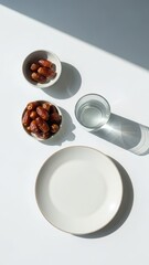 A simple minimalist iftar setting with dates and water on a white table, conveying calm Ramadan reflection, spiritual focus, and modest celebration suitable for modern lifestyle and religious content