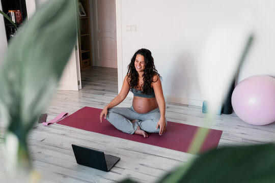 Pregnant woman preparing for an online workout at home