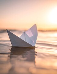 Obraz premium A solitary paper boat floats serenely on shimmering water at sunset
