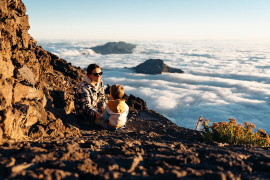 Mother and son watching clouds from mountain top