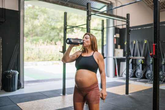Pregnant woman hydrating during functional training workout