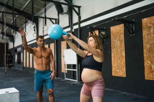 Pregnant woman training with kettlebell during cross-training session