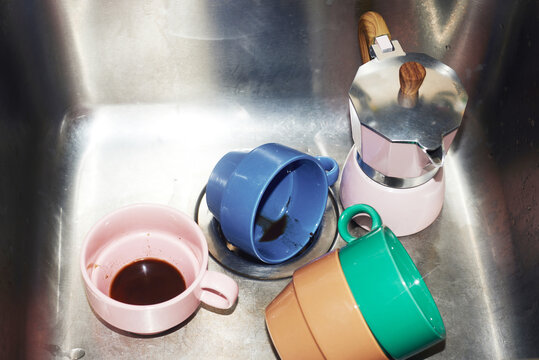Geyser coffee maker and colorful cups in the sink