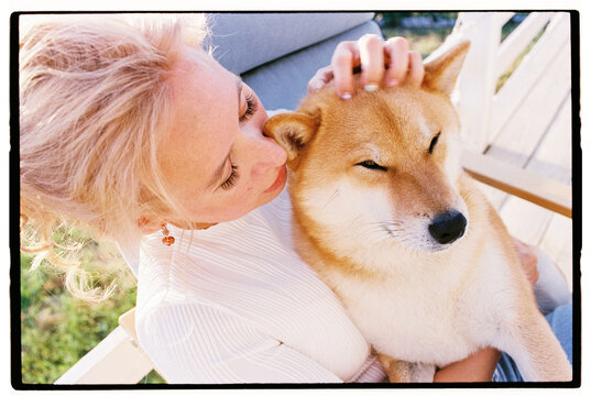 Film closeup portrait of a woman tenderly stroking her Shiba Inu dog