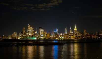 New York City at night. NYC cityscape with skyscrapers. Panoramic of New York City skyline on dusk. Manhattan skyline. New York and Hudson River. Downtown NYC. New York skyscrapers on sunset.