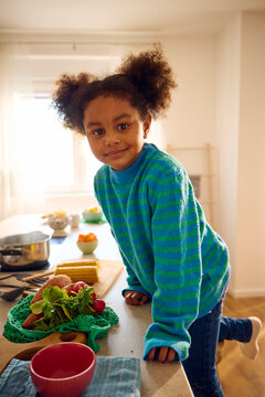 Little girl climbs the kitchen counter