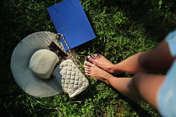 Barefoot woman stands on grass. Barefoot summer moment. Barefoot freedom and natural comfort. Barefoot concept with nature.