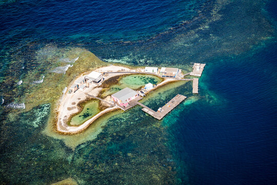 Tiny reef outpost surrounded by deep blue water.