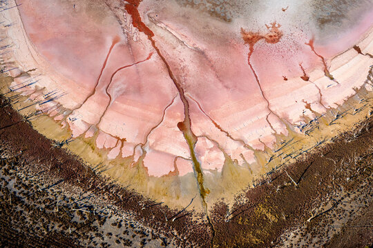 Pink salt lake patterns with cracked textures and radiating channels