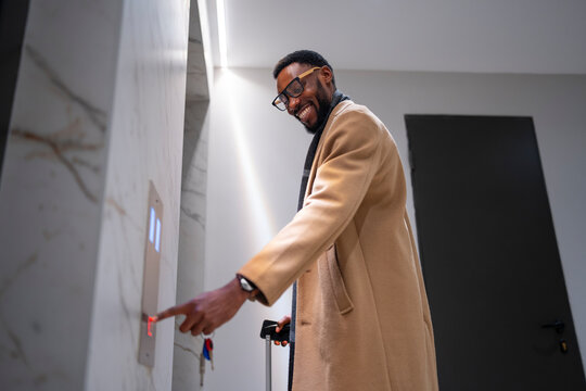 Man with cane waiting for elevator in modern building lobby