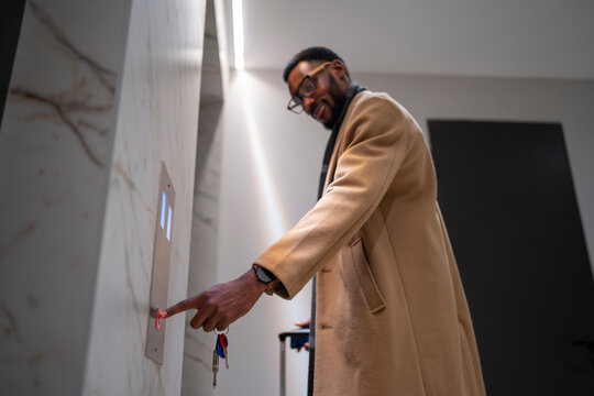 Man pressing elevator button in modern building lobby