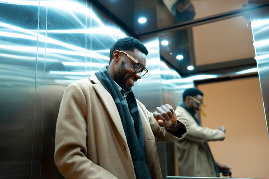 Businessman checking time in elevator